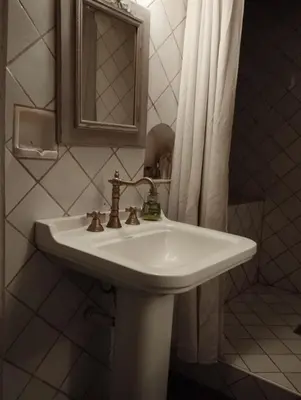 a white bathroom sink with a mirror and a shower curtain at Entre Terre et Ciel. in Saignon