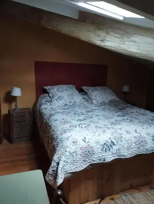 a bedroom with a bed with a wooden bed frame at Entre Terre et Ciel. in Saignon