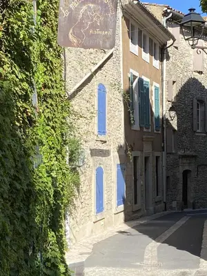 a building with a sign on the side of a street at Entre Terre et Ciel. in Saignon