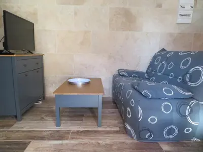 a living room with a couch and a table at Maison 4 étoiles et Studio 3 étoiles indépendants avec piscine in LʼIsle-sur-la-Sorgue