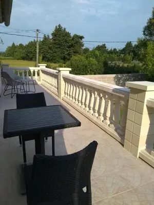 a patio with two tables and chairs on a balcony at Maison 4 étoiles et Studio 3 étoiles indépendants avec piscine in LʼIsle-sur-la-Sorgue