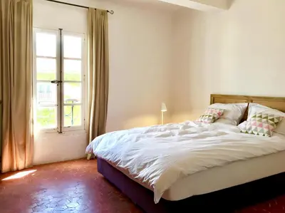 a bedroom with a large bed and a window at la bonbonniere - Townhouse Saint-Saturnin-lès-Apt in Saint-Saturnin-les-Apt