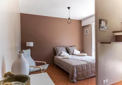 a bedroom with a bed and a chair at Au Coeur des Vignes en Provence in Châteauneuf-de-Gadagne