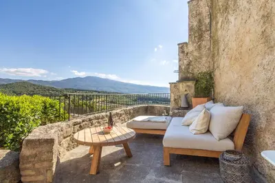a patio with a couch and a table at Maison Ventoux in Crillon-le-Brave