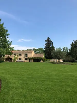 a large green yard with a house in the background at FOUR DE CONY in Saumane-de-Vaucluse