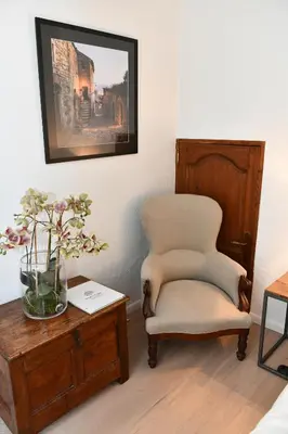 a room with a chair and a table with a vase of flowers at FOUR DE CONY in Saumane-de-Vaucluse