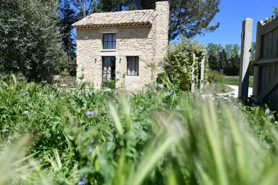 a stone house in the middle of a field of grass at FOUR DE CONY in Saumane-de-Vaucluse