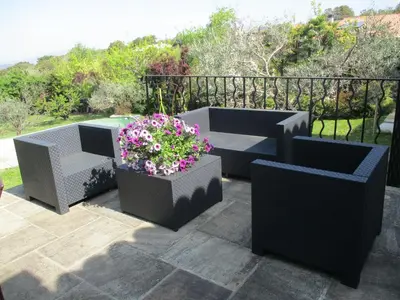 a patio with two seats and a table and flowers at Gîte du Jardin des Espuys in Venasque