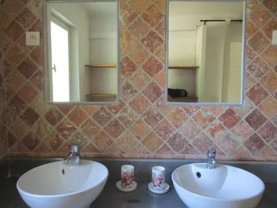 a bathroom with two sinks and a mirror at Gîte du Jardin des Espuys in Venasque