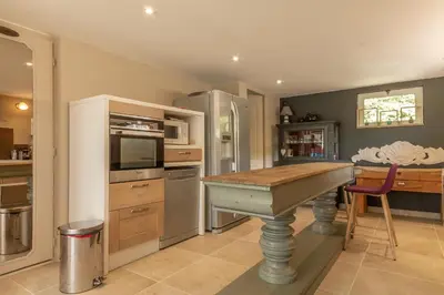 a kitchen with a counter and a table in it at Maison Beally in Eyragues