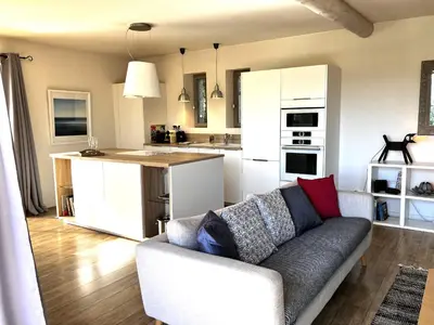 a living room with a couch and a kitchen at Le Mas les Pléiades - Private pool - Gordes in Gordes