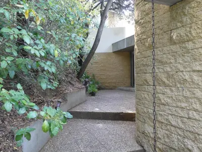 a walkway leading into a building with a tree at les 3 saisons in Cucuron