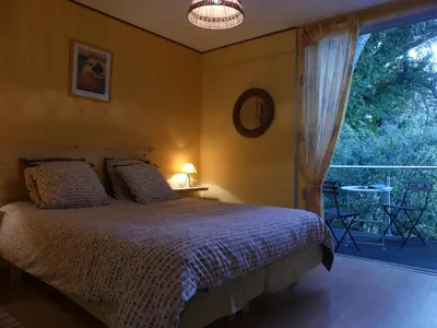 a bedroom with a bed and a large window at les 3 saisons in Cucuron