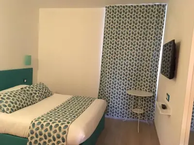a small room with a bed and a table at Brit Hotel Salon de Provence in Salon-de-Provence