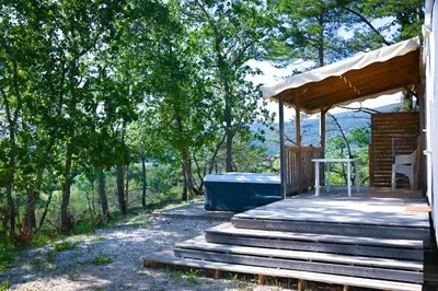 a wooden deck with a hot tub on top of it at Camping le Colorado in Rustrel