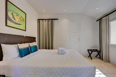 a bedroom with a large bed with blue pillows at Hostellerie Le Paradou in Lourmarin