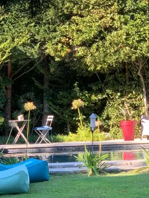 a swimming pool in a yard with chairs and a table at La demeure in Eyguières
