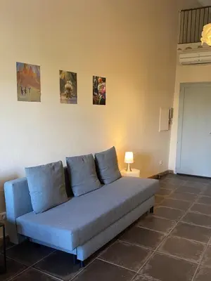 a blue couch in a room with paintings on the wall at 13 QUAI JEAN JAURES in LʼIsle-sur-la-Sorgue