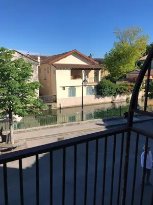 a man standing on a balcony looking at a street at 13 QUAI JEAN JAURES in LʼIsle-sur-la-Sorgue