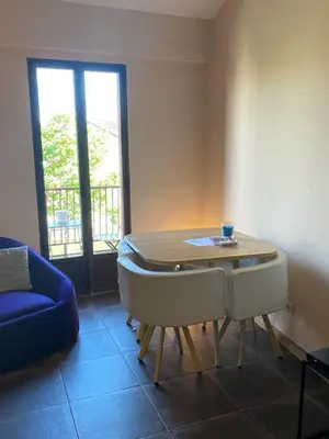 a dining room with a table and a blue couch at 13 QUAI JEAN JAURES in LʼIsle-sur-la-Sorgue