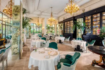 a dining room with tables and chairs and chandeliers at Villa Saint-Ange in Aix-en-Provence