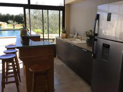 a kitchen with a refrigerator and a counter with stools at Large family home with private pool in Vignères, 10 sleeps. in Cavaillon