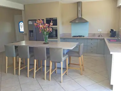 a kitchen with a table with chairs and a vase of flowers at Large family home with private pool in Vignères, 10 sleeps. in Cavaillon