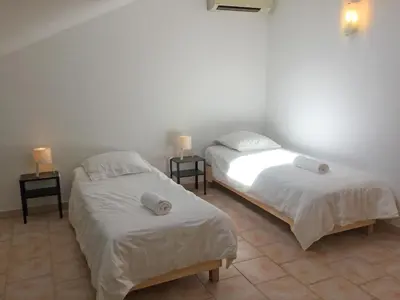 two beds in a room with white sheets and pillows at Large family home with private pool in Vignères, 10 sleeps. in Cavaillon