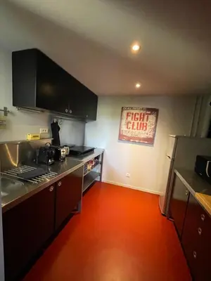 a kitchen with black cabinets and a red floor at Loft 52 in Aix-en-Provence