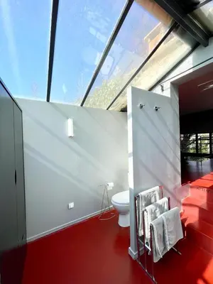 a bathroom with a toilet and a red floor at Loft 52 in Aix-en-Provence
