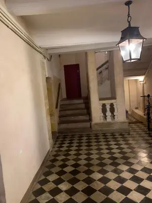 a hallway with a checkered floor and a red door at L'Appart 6 in Aix-en-Provence