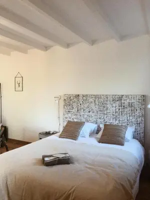 a bedroom with a large bed with a large headboard at Domaine de Carraire in Aix-en-Provence