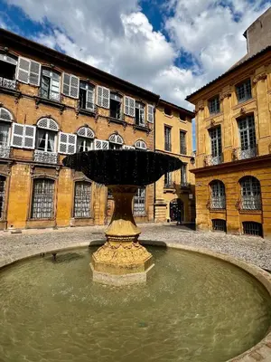 a fountain in the middle of a courtyard with a building at Maison Alberta in Aix-en-Provence