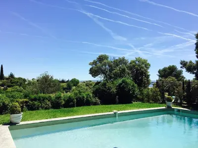 a swimming pool in front of a yard with trees at Le Clos de Manon in Gordes