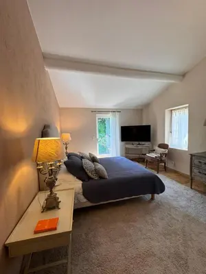 a bedroom with a bed and a table with a lamp at Le Clos de Manon in Gordes