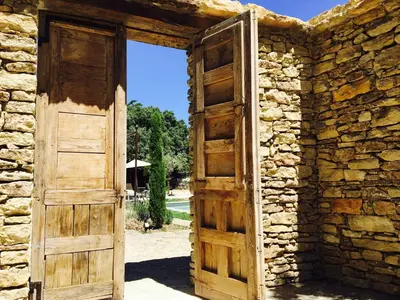 an open door to a stone building with an open window at Le Clos de Manon in Gordes