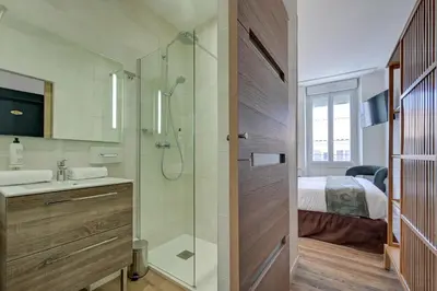 a bathroom with a shower and a sink and a bed at Urban Style Hotel Blason du Ventoux in Carpentras