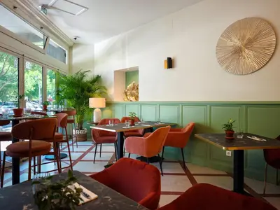 a restaurant with green walls and tables and chairs at Urban Style Hotel Blason du Ventoux in Carpentras