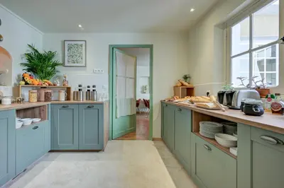 a kitchen with blue cabinets and a large window at Urban Style Hotel Blason du Ventoux in Carpentras