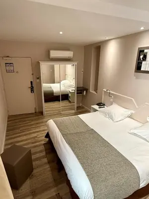 a hotel room with a large bed and a mirror at Urban Style Hotel Blason du Ventoux in Carpentras
