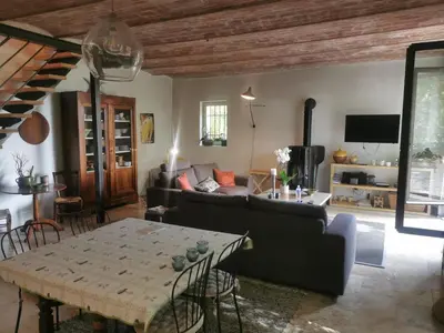 a living room with a couch and a table at Le Provençal Duplex piscine jardin le Luberon in Puyvert