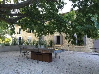 a table and chairs in front of a building at Le Provençal Duplex piscine jardin le Luberon in Puyvert
