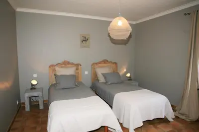 a bedroom with two beds and a pendant light at le jas de Saint Hilaire in Ménerbes