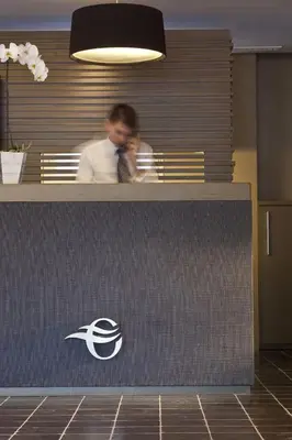 a man standing behind a counter in an office at Escale Oceania Aix-en-Provence in Aix-en-Provence