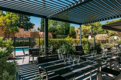a patio with tables and chairs and a pool at Escale Oceania Aix-en-Provence in Aix-en-Provence
