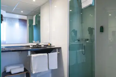 a bathroom with a glass shower and a sink at Escale Oceania Aix-en-Provence in Aix-en-Provence