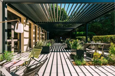 a patio with tables and chairs under awning at Escale Oceania Aix-en-Provence in Aix-en-Provence