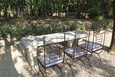 two chairs sitting next to a table in a park at Le Hameau Fleur de Pierres , Chambre , Gite et Table d'Hôtes in Murs