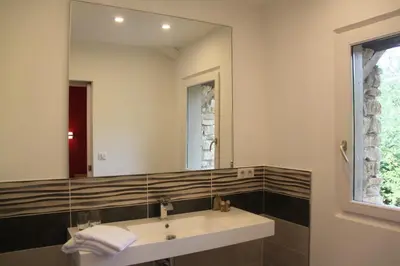 a bathroom with a sink and a large mirror at Le Hameau Fleur de Pierres , Chambre , Gite et Table d'Hôtes in Murs
