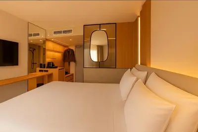 a bedroom with a large white bed with pillows at Golden Tulip Avignon Le Paradou in Avignon